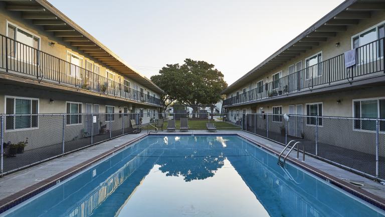 A picture of the exterior apartments and pool of the Clayburn Apartments in San Jose